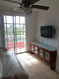 a living room with a flat screen tv and a bed at punta sam in front isla mujeres in Cancún