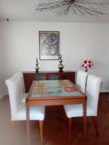 jadalnia ze stołem i 2 białymi krzesłami w obiekcie punta sam in front isla mujeres w mieście Cancún