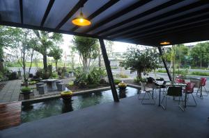 a patio with a pool and a table and chairs at At 24 Boutique Hotel in Nakhon Si Thammarat