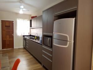 una cocina con refrigerador de acero inoxidable en Casa piscina próxima praia, en Florianópolis