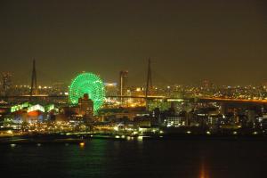 a city skyline with a ferris wheel at night at HOTEL FUKURACIA OSAKA-BAY in Osaka
