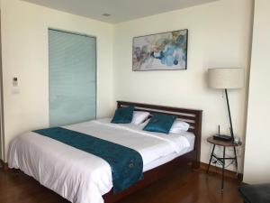 a bedroom with a large bed with blue pillows at The palm wongamat pattaya in Pattaya North