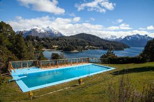 a swimming pool with a view of a lake and mountains at Hotel Amancay in San Carlos de Bariloche