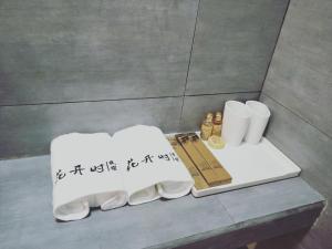 都江堰花开时民宿的两条白色毛巾,在柜台上写