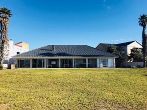 a house with a large lawn in front of it at 39 Kabeljauws Road Beach House in Jeffreys Bay