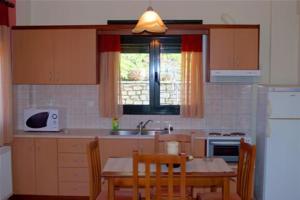 a kitchen with a table and chairs and a sink at Guesthouse Anthoula in Dervíziana