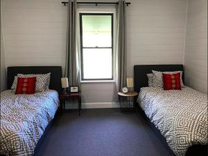 1 dormitorio con 2 camas y ventana en Bobby's Country Rental, en Eccleston