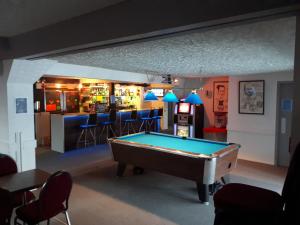 una mesa de billar en una habitación con bar en Hôtel Aux Vieux Bardeaux, en Deschambault