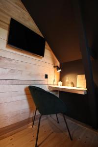 um quarto com uma televisão e uma cadeira verde em Davids Kulle em Ronneby