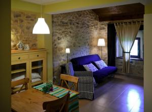 a living room with a purple couch and a table at Apartamentos Playa Galizano in Galizano