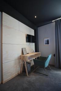 uma secretária com um computador portátil e uma cadeira num quarto em Davids Kulle em Ronneby