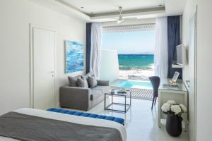 a hotel room with a bed and a couch and a window at Knossos Beach Bungalows Suites Resort & Spa in Kokkíni Khánion