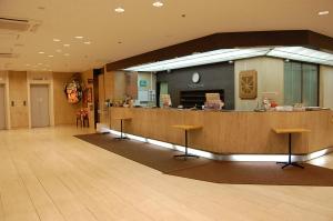 a large lobby with a counter with stools at Hotel Sunroute Aomori in Aomori