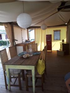 a wooden table with chairs and a dining room at Camping Paradiso in Viareggio