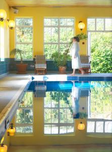 a woman walking in front of a swimming pool at The Dunraven, Adare in Adare
