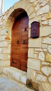 コロニにあるOnirozo Koroni Private Villaの石造りの建物側の木製の扉