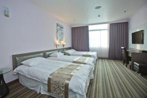 a hotel room with two beds and a desk at Hotel River Kinmen in Jincheng