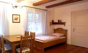 um pequeno quarto com uma cama, uma mesa e uma janela em U Leknínu em Doksy
