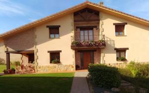 una casa con un balcón con flores. en El Chalet Del Golf en Urturi