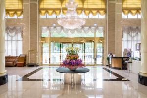 un vestíbulo con una mesa con un jarrón de flores. en Royal Chiayi Hotel en Chiayi