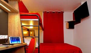 - une chambre avec des lits superposés et un bureau avec un ordinateur portable dans l'établissement In Hotel Nancy Frouard, à Frouard