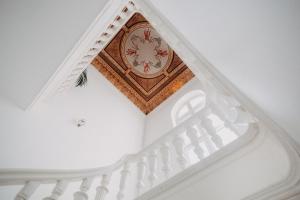 a white staircase with a clock on the ceiling at Matejki 8 in Szczecin