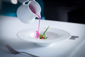 a white plate with a pink dessert on a table at Matejki 8 in Szczecin