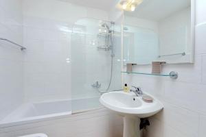 a white bathroom with a sink and a shower at Agriturismo Pimpinnacolo in Porto Ercole
