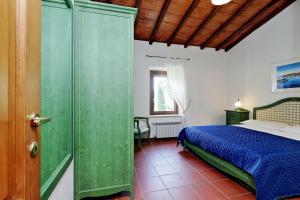 a bedroom with a bed and a green door at Agriturismo Pimpinnacolo in Porto Ercole