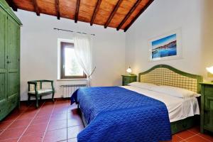 a bedroom with a bed with a blue comforter at Agriturismo Pimpinnacolo in Porto Ercole