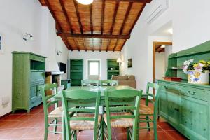 a kitchen with green cabinets and a table and chairs at Agriturismo Pimpinnacolo in Porto Ercole