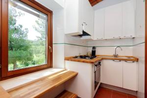 a small kitchen with a window and a sink at Agriturismo Pimpinnacolo in Porto Ercole
