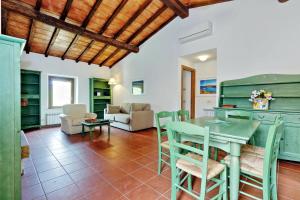 a kitchen and living room with a table and chairs at Agriturismo Pimpinnacolo in Porto Ercole