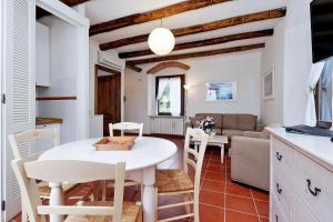 a kitchen and living room with a white table and chairs at Agriturismo Pimpinnacolo in Porto Ercole
