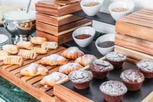 a tray of pastries and muffins on a table at Evo Boutique Hotel & SPA in Bellaria-Igea Marina +181 photos