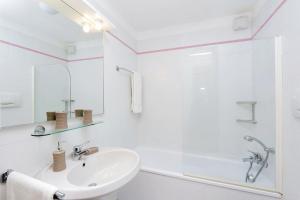 a white bathroom with a sink and a shower at Agriturismo Pimpinnacolo in Porto Ercole
