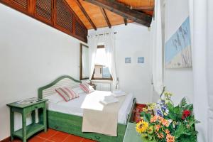 a bedroom with a bed and a window and flowers at Agriturismo Pimpinnacolo in Porto Ercole