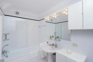 a white bathroom with a sink and a mirror at Agriturismo Pimpinnacolo in Porto Ercole