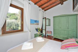 a bedroom with a green cabinet and a window at Agriturismo Pimpinnacolo in Porto Ercole