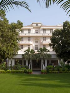 a large white building with trees in front of it at Ambassador, New Delhi - IHCL SeleQtions in New Delhi