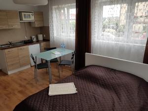 una camera con letto e tavolo e una cucina di Apartamenty Nadmorskie a Władysławowo