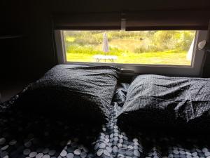 una cama en una habitación con ventana en Lodge, en Ville-sur-Ancre