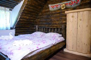 1 dormitorio con 1 cama en una cabaña de madera en Non Nobis Dambovicioara, en Dîmbovicioara