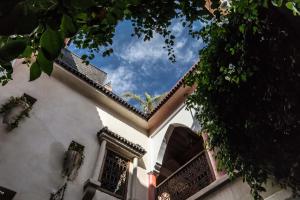 a white building with a roof and the sky at Riad Le Plein Sud in Marrakech