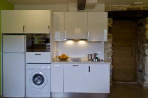 a kitchen with white cabinets and a washing machine at Apartamentos Playa Galizano in Galizano