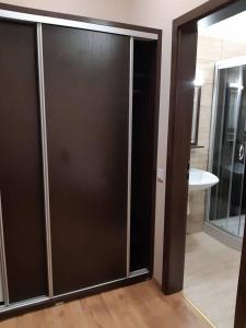 a bathroom with a glass shower door with a sink at Pazonyi Fogadó és Étterem in Nyírpazony