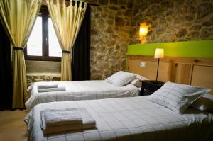 a bedroom with two beds and a green wall at Apartamentos Playa Galizano in Galizano