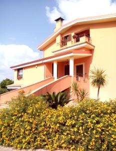 ein Gebäude mit gelben Blumen davor in der Unterkunft Villa Laregina in Grisolia