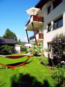 a hammock in a yard in front of a building at Appartements Margot in Krumpendorf am Wörthersee