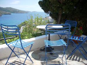 two blue chairs and a table with a view of the water at Blue Dolphin in Batsi